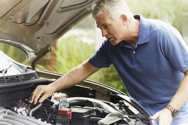 homem verificando motor do carro